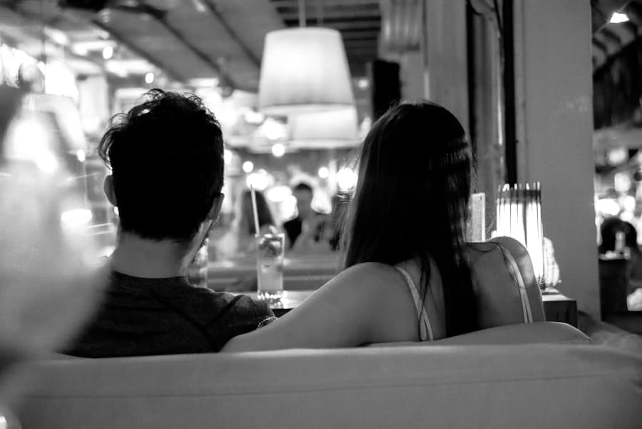 A couple at a café, mid-conversation — tension underneath the surface